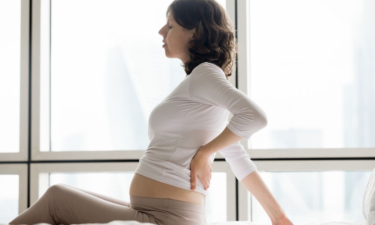 Imagem de uma mulher recém-grávida com dor nas costas