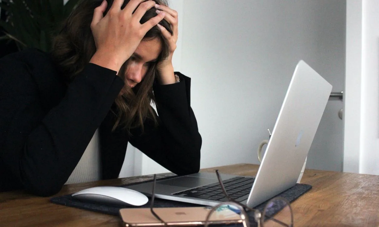 Imagem de uma mulher jovem estressada com as mãos na cabeça